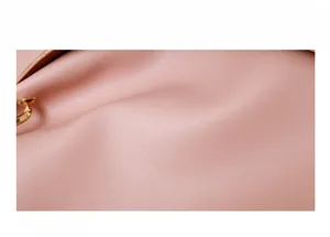 Macro shot of pink textured faux leather and gold metal hardware for bucket bag