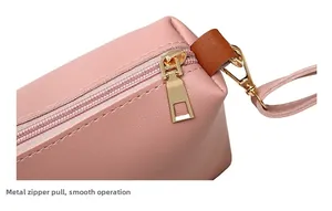 Detail of pink PU leather pouch featuring smooth golden metal zipper and durable hardware