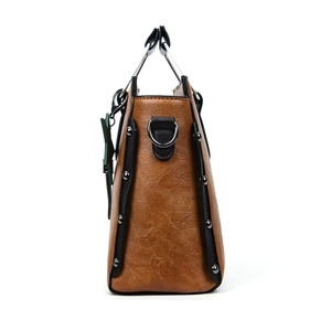Détail du sac en cuir ciré marron vintage avec bordure noire et rivets argentés