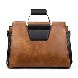 Détails du sac cabas vintage montrant le cuir marron grainé et les rivets argentés déco