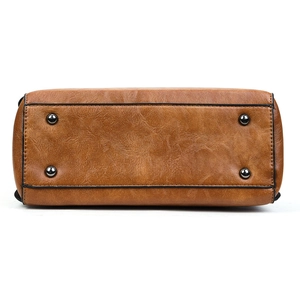 Vue détaillée du fond du sac en similicuir marron avec quatre pieds de protection en métal