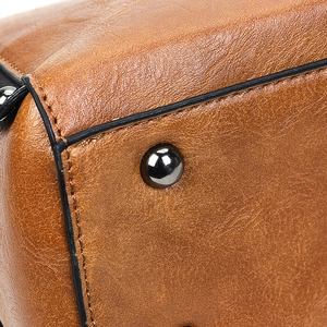 Détails macro de la base du sac en cuir marron vintage avec clous de protection en métal