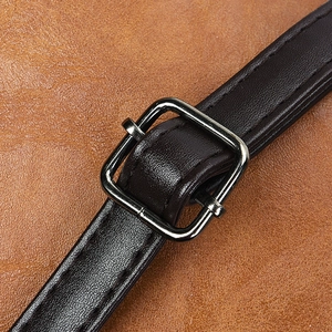Détail de la bandoulière en cuir marron et boucle métallique sur un sac à main femme