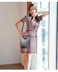 Gray leather crossbody bucket bag shown with a red and white striped knit dress