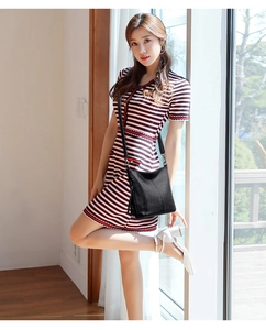 Close-up of black litchi pattern leather bucket bag with fringe tassel and slender strap
