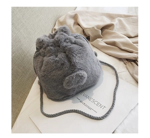 Detailed close-up of grey plush drawstring bucket bag with soft faux fur texture