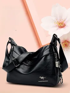Close-up of black leather handbag featuring silver hardware and brand kangaroo logo