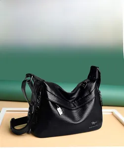Detail of black soft leather crossbody bag with metal logo and multi-zipper pockets