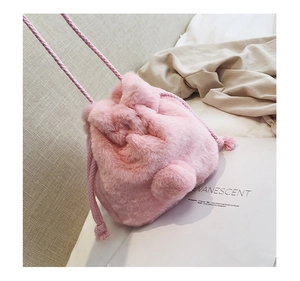 Detailed view of pink plush bucket bag with drawstring closure on soft fabric background