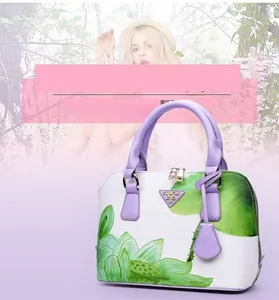 Detail of shell bag with green lotus print, purple handles and gold triangular logo