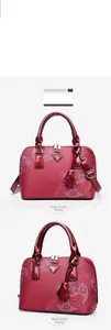 Detailed front and side view of red paisley patterned handbag with triangular logo
