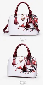Detail view of burgundy wine shell bag with plum blossom print and gold zipper