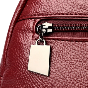Deep red leather backpack with premium lychee grain and metal zipper detail