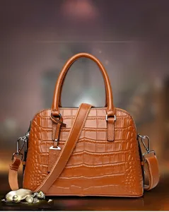 Detailed view of the brown crocodile pattern texture and silver hardware on this handbag