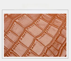 Macro shot of caramel brown crocodile embossed leather texture on a cowhide handbag