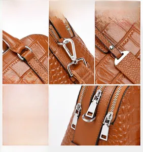Close-up of brown crocodile texture leather bag with silver hardware and reinforced stitching