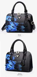 Detail view of black Saffiano leather bag with blue floral print and golden zippers