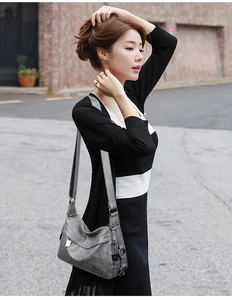 Gray soft leather crossbody bag shown on shoulder in a realistic outdoor setting