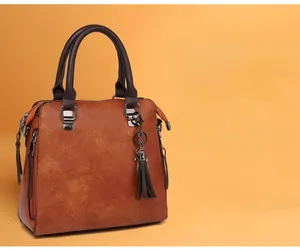 Dettaglio della borsa a mano caramello con texture fine ed elegante nappa decorativa