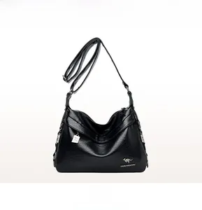 Front view of black soft leather crossbody bag with kangaroo logo and white decorative charm