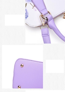 Close-up of golden hardware, crossbody strap hooks and base studs on lavender floral bag