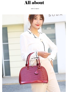 Elegante borsa a conchiglia rossa con trama a coccodrillo portata da una modella