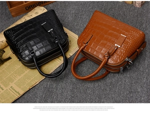Detail of crocodile embossed handbags in black and brown with dual zipper structure