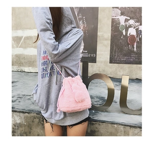 Detail of pink faux fur bucket bag with drawstring closure and soft plush texture