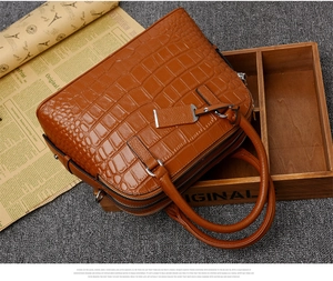 Detail of crocodile embossed leather handbag with silver hardware and double zippers