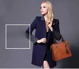 Borsa a mano vintage marrone con doppi manici e nappa indossata dalla modella