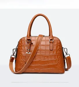 Front view of brown crocodile embossed shell bag with dual handles and metal zipper