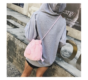 Detailed close-up of pink faux fur bucket bag with drawstring and thin shoulder strap