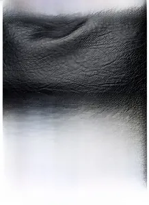 Close-up of premium black lychee leather texture and silver kangaroo logo on handbag