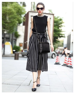 Elegante borsa a tracolla in pelle nera con fibbia in metallo mostrata in un look street