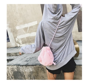 Detail view of pink plush drawstring bucket bag showing soft faux fur texture on the street