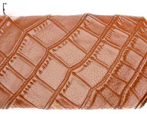 Close-up of caramel brown cowhide leather with embossed crocodile texture on the handbag