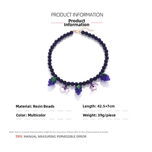 Detailed view of handmade beaded necklace featuring purple resin grape and flower charms
