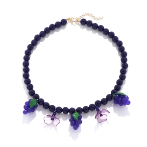 Beaded necklace featuring purple grape charms and flower pendants with a gold lobster clasp