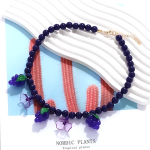 Handmade beaded necklace with purple grape and flower pendants in a fresh vacation style