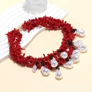Detailed shot of red coral-style branch beads and large baroque pearl pendant necklace