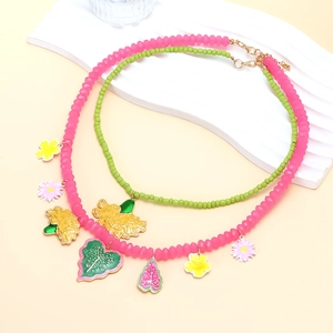Detail view of double-layered beaded necklace with colorful enamel flower pendants