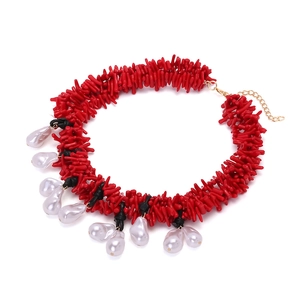 Detailed view of red coral beads necklace with baroque pearls and gold-plated chain