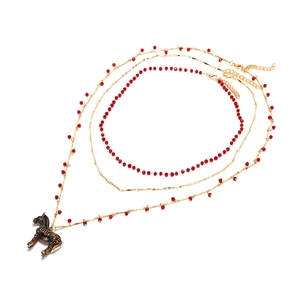 Collier vintage à trois rangs doré avec pendentif zèbre et perles rouges sur fond blanc