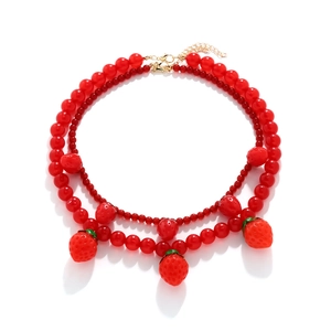 Collier double rang de perles rouges avec pendentifs fraises et fermoir doré