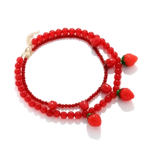 Collier multi-rangs en perles rouges avec pendentifs fraises et fermoir doré