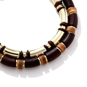 Close-up of geometric wooden and amber resin beads on a gold double-layer necklace