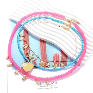 Multi-layer beach necklace with starfish, shell and fish pendants on summer display