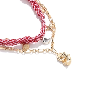 Close-up of layered ocean necklace with starfish shells and red woven fabric cord