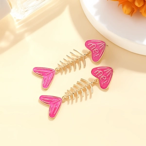 Detail of rose red enamel fishbone earrings with golden metal and me lettering