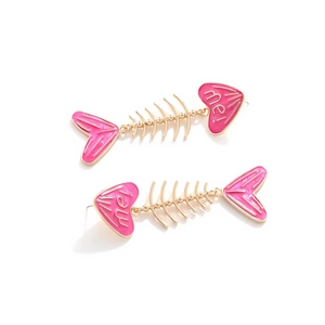 Detailed macro shot of pink and gold fishbone earrings with heart design and me text